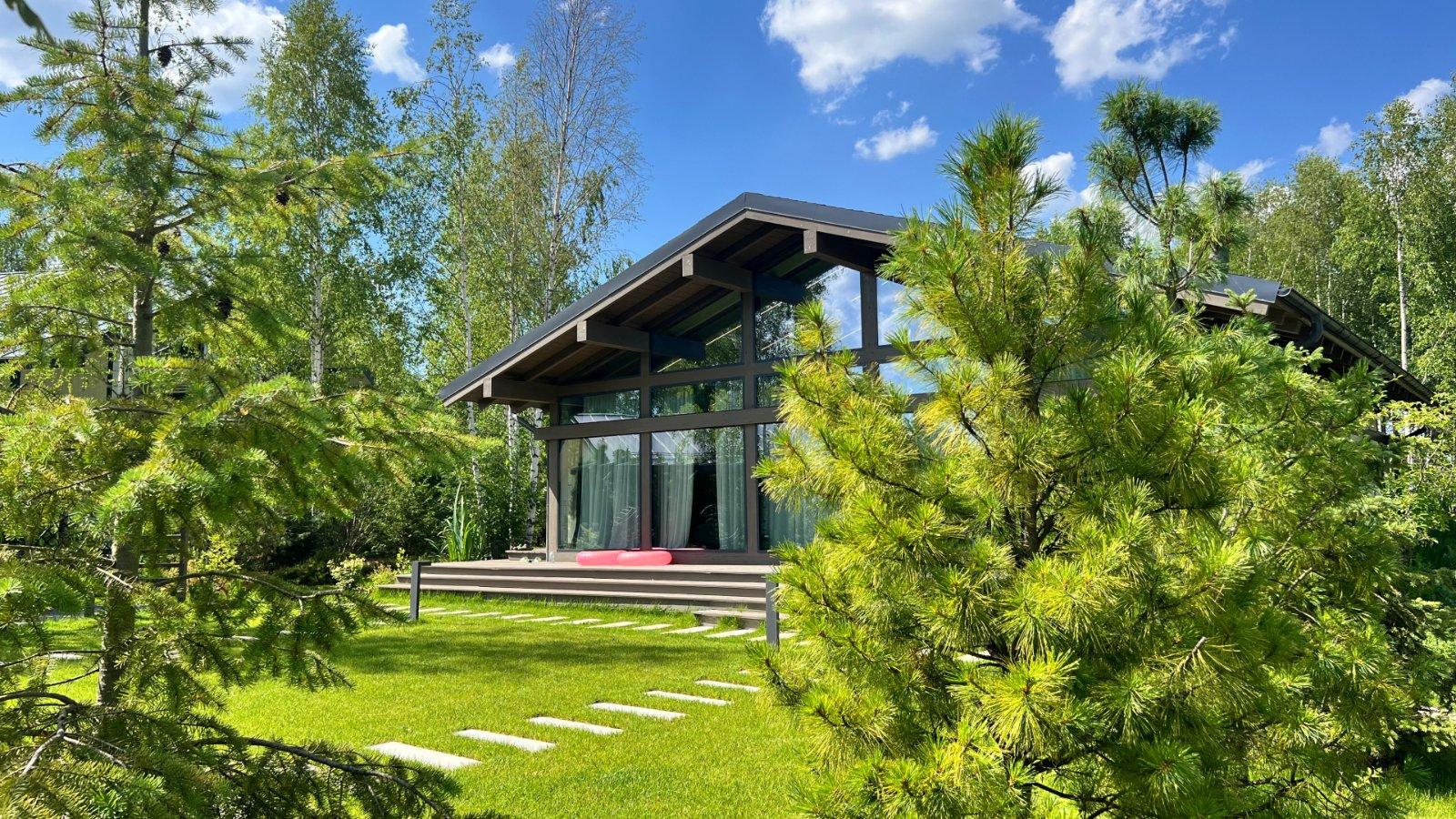 Современный дом у воды в посёлке Bayside Residence среди хвойного леса